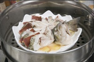 將鱸魚成花狀擺好，將火腿切片放入各縫隙中，放入鍋中隔水蒸12分鐘拿出，撒上蔥花即可。