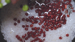 將炒好的食材和大米、紅豆一起放進(jìn)電飯鍋煮。
