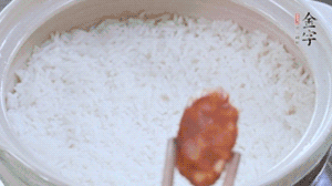煮開后轉小火，當米飯出現(xiàn)小孔時，鋪上金字麻辣香腸。