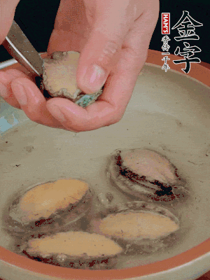 鮑魚加鹽、清水浸泡，用勺子挖出鮑魚肉。