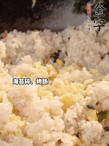 剩米飯下鍋炒散，依次下玉米粒、雞蛋、烤腸、海苔碎翻炒均勻。