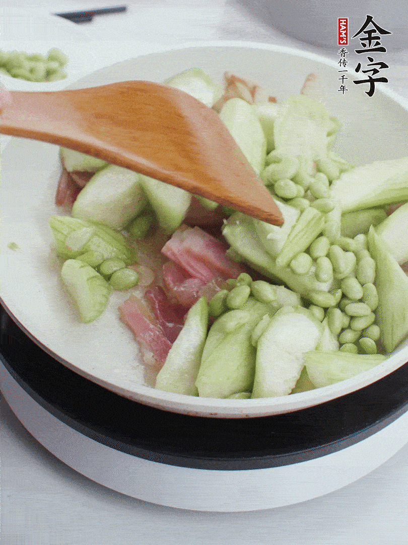 依次下絲瓜、青豆翻炒，炒至絲瓜打蔫縮小。