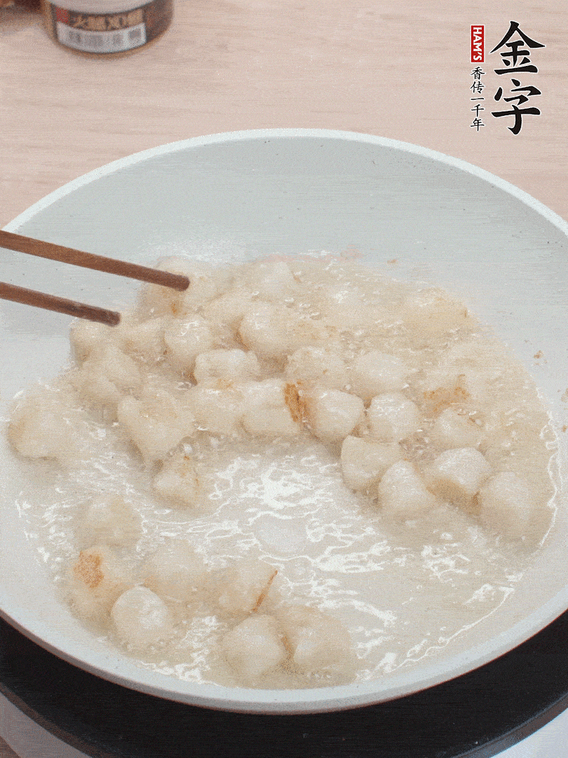 油溫4成熱，鮮貝蘸干淀粉下鍋煎，一面微黃后翻面。