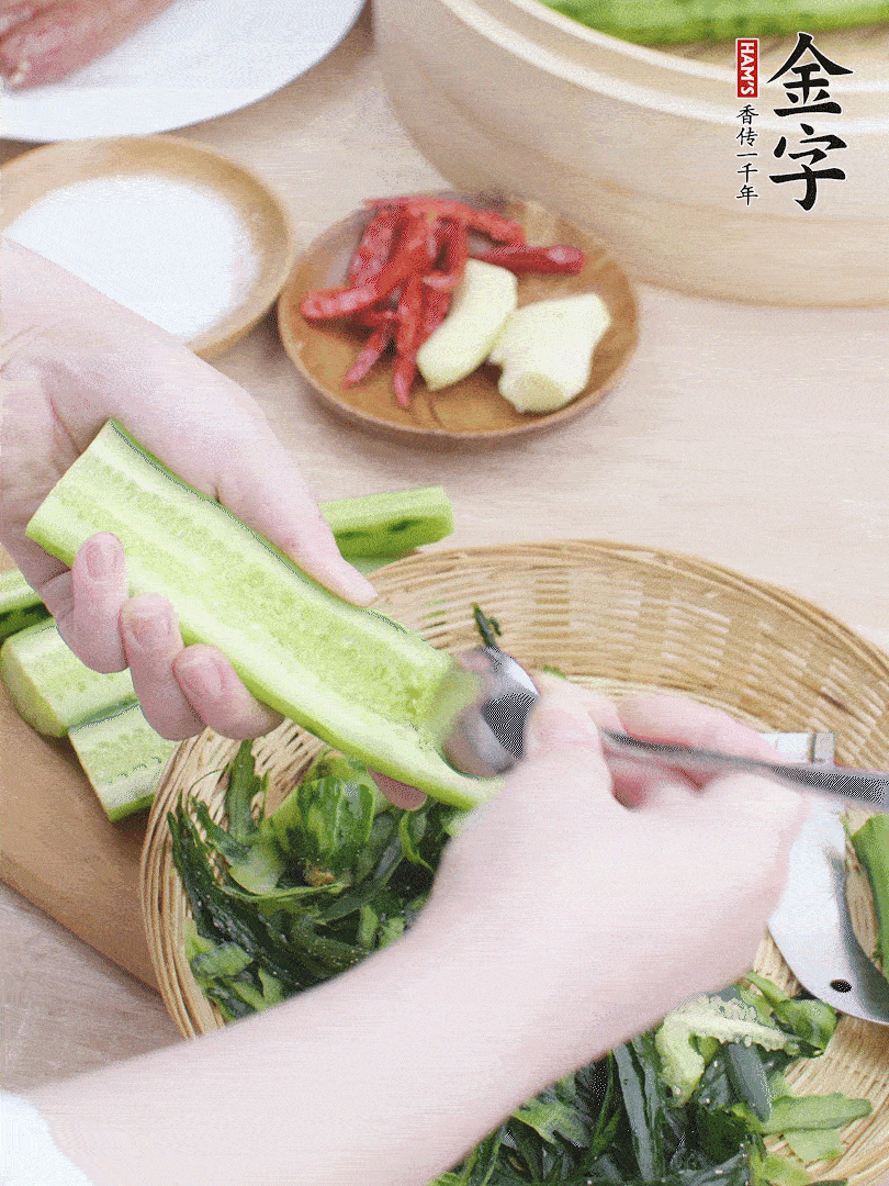 黃瓜削皮，對(duì)半切開，勺子挖去內(nèi)瓤，斜刀切片。青蒜斜刀切段。