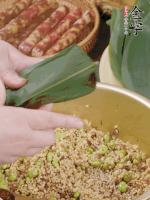 粽葉往下折，完全蓋住，兩側(cè)捏緊。