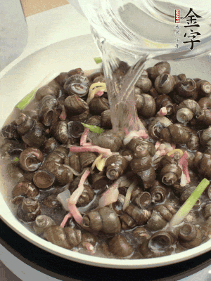 倒處理干凈的螺螄翻炒，加3勺料酒。加清水蓋過螺螄，中火蓋蓋煮5分鐘。