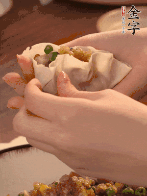 取一大勺餡料放進餃子皮里，用大拇指按住頂部餡料，再用虎口掐出形狀。