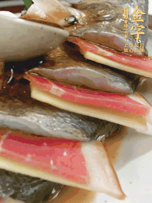 魚肚中塞蔥結、火腿片，魚身上碼放姜片、火腿片，倒入混合的料汁。