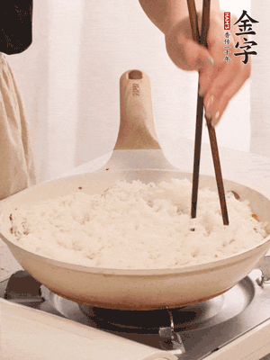 把瀝干水分的米飯均勻鋪在上面，筷子戳幾個(gè)洞，以便透氣，轉(zhuǎn)小火蓋上蓋子燜至水分收干，大概10分鐘。